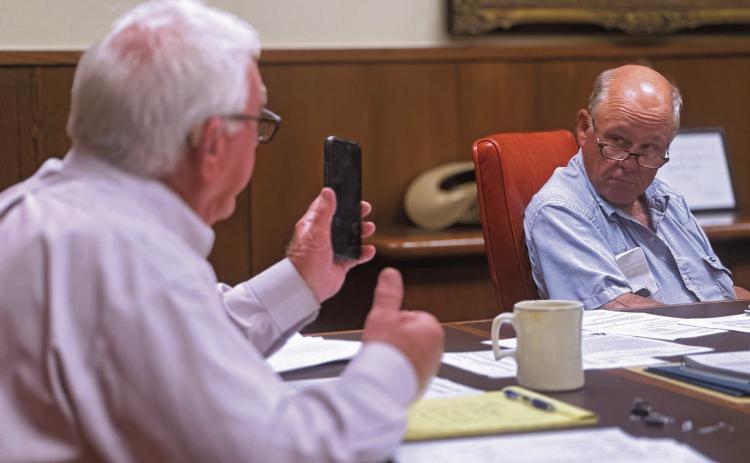 Stonewall County Judge Ronnie Moorhead and Commissioner Gary Myers listen in as County Attorney Riley Branch provides legal guidance regarding the county’s cemetery maintenance contract.