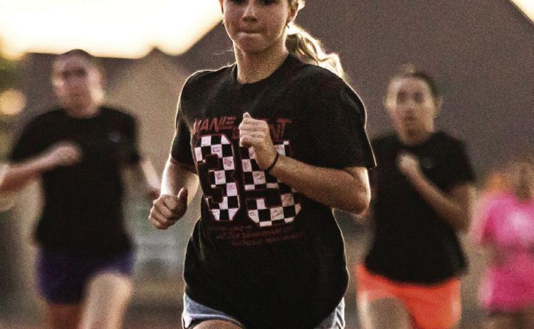 Lady Lion XC senior Lilly Benson leads the pack during the teams' morning workout. PHOTO MARK MARTINEZ