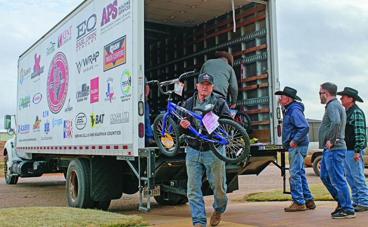 Rotan Methodist Church member Brett Clemmos helps unload a truck full of bikes, sports equipment, and toys with fellow parishioners waiting for the next load from Larry Sauls &amp; Friends in their third annual delivery.