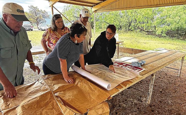 Locals check the Newman Cemetery map for reserved spots no longer needed. Photo Submitted by