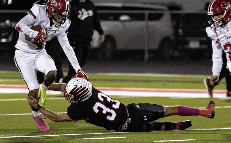 Left: Roby's Camden Carrion fights through a leg tackle during the Lion's district contest with Hermleigh last Friday night. Photo by: Mark Martinez