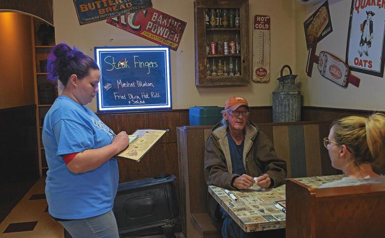 Brittnay Gonzalez takes Mike Bookman and his daughter's order during their lunch rush at Hickman's Restaurant, now open to full capacity since Gov. Abbott lifted restrictions earlier this month in the efforts to reopen Texas 100 percent.