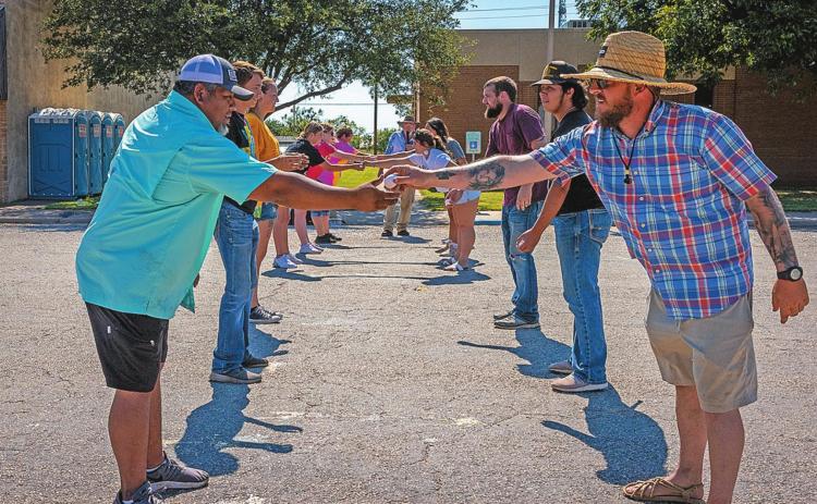 Aspermont's City Administrator Lorenzo Calamaco (left) receives the egg hand off from Mayor Steven Ellis (right) during the Egg Toss finals.