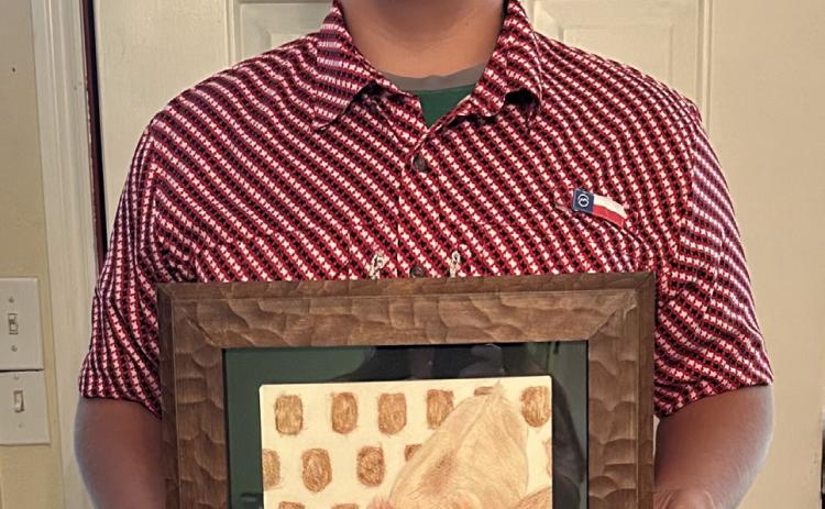 James Bell holds his award-winning mixed media painting, Tater Tot, which was selected as the Congressional Art Competition winner for Texas’ 19th District.