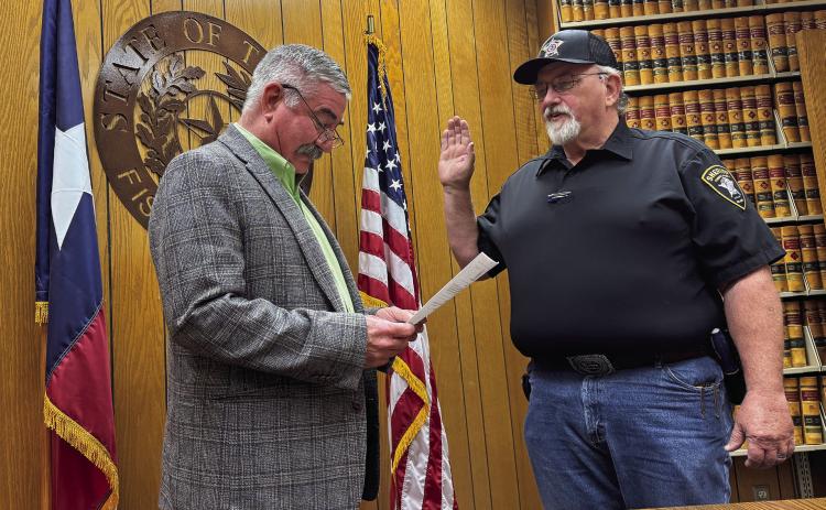 Fisher County Judge Ken Holt administers the oath of office to newly appointed Sheriff John Dickson on Monday, January 6.